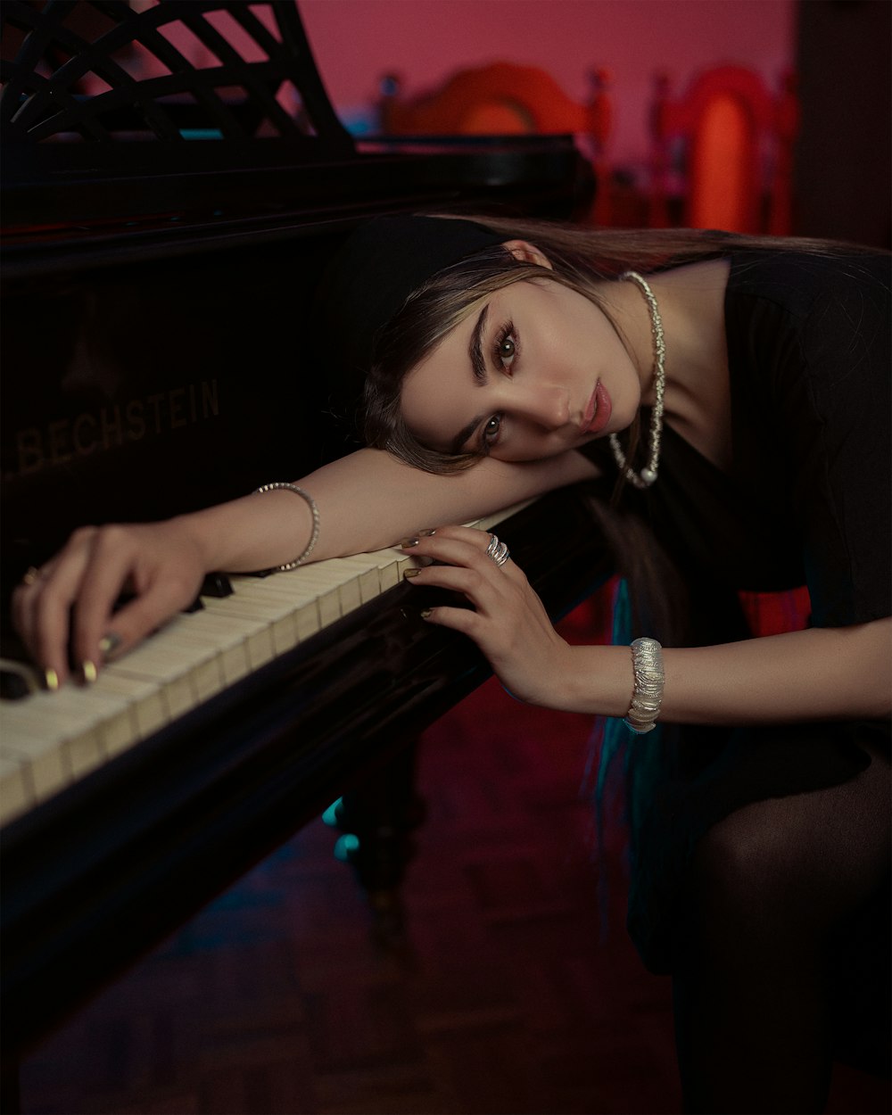 a woman leaning on a piano in a room