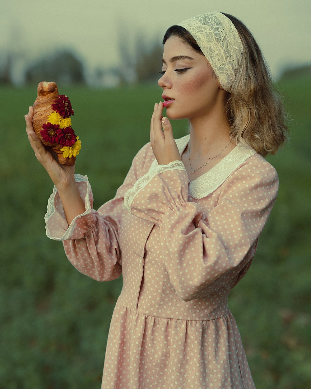 a woman in a polka dot dress holding a hot dog