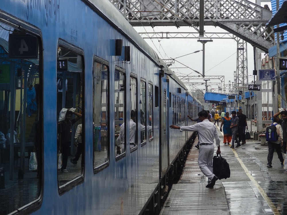 a group of people walking next to a train