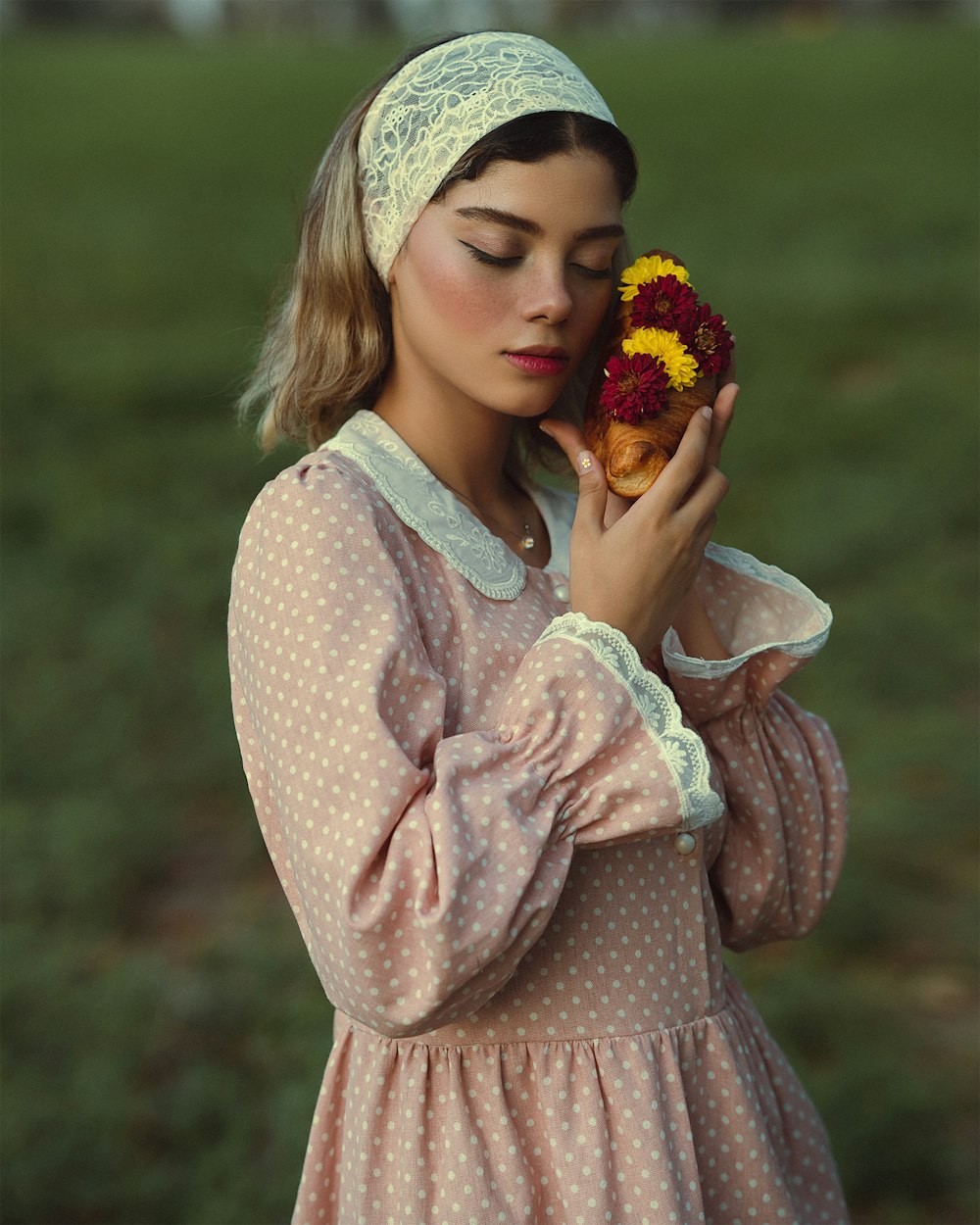 a woman in a pink dress holding a flower