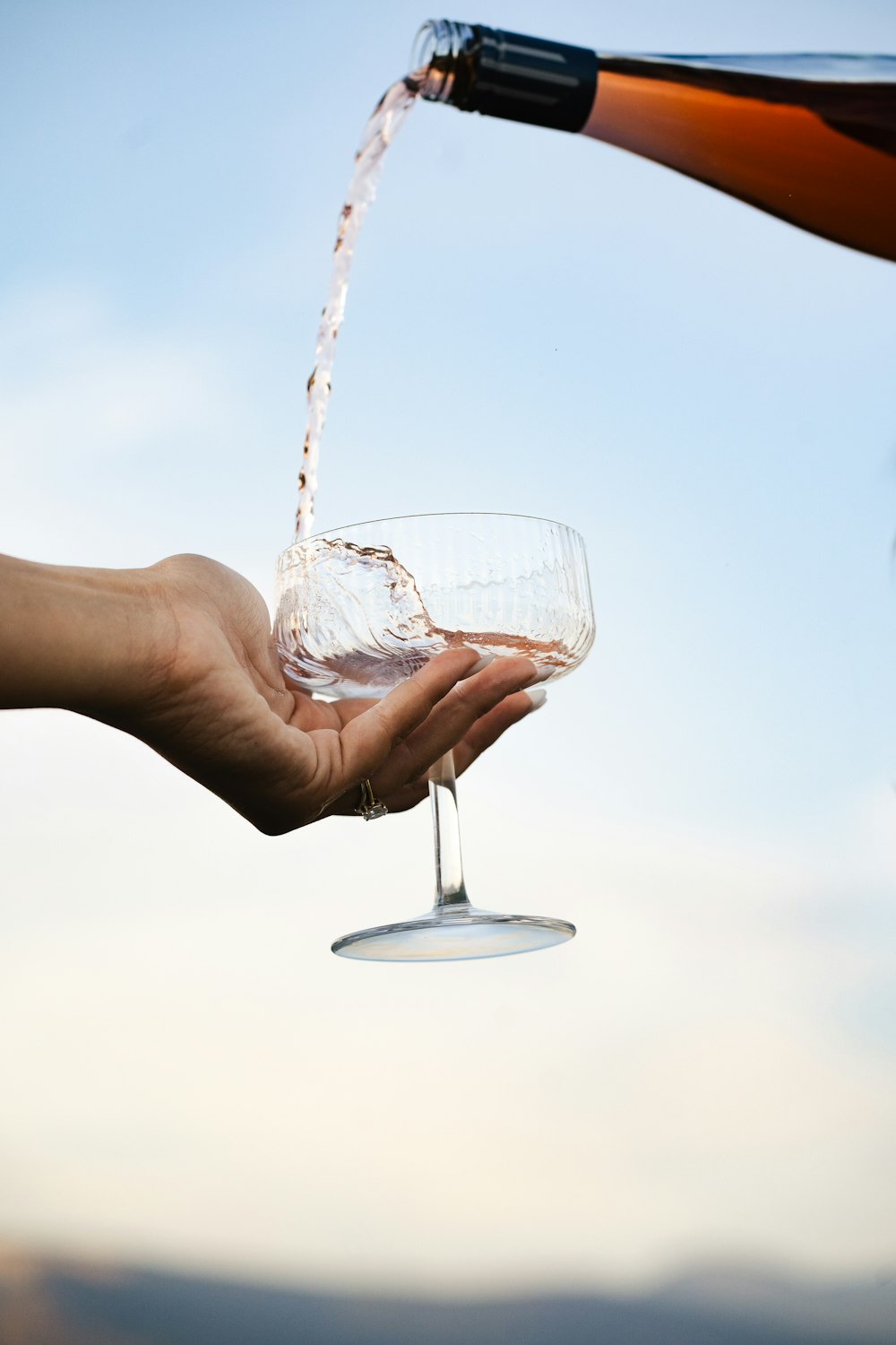 a person is pouring a glass of wine