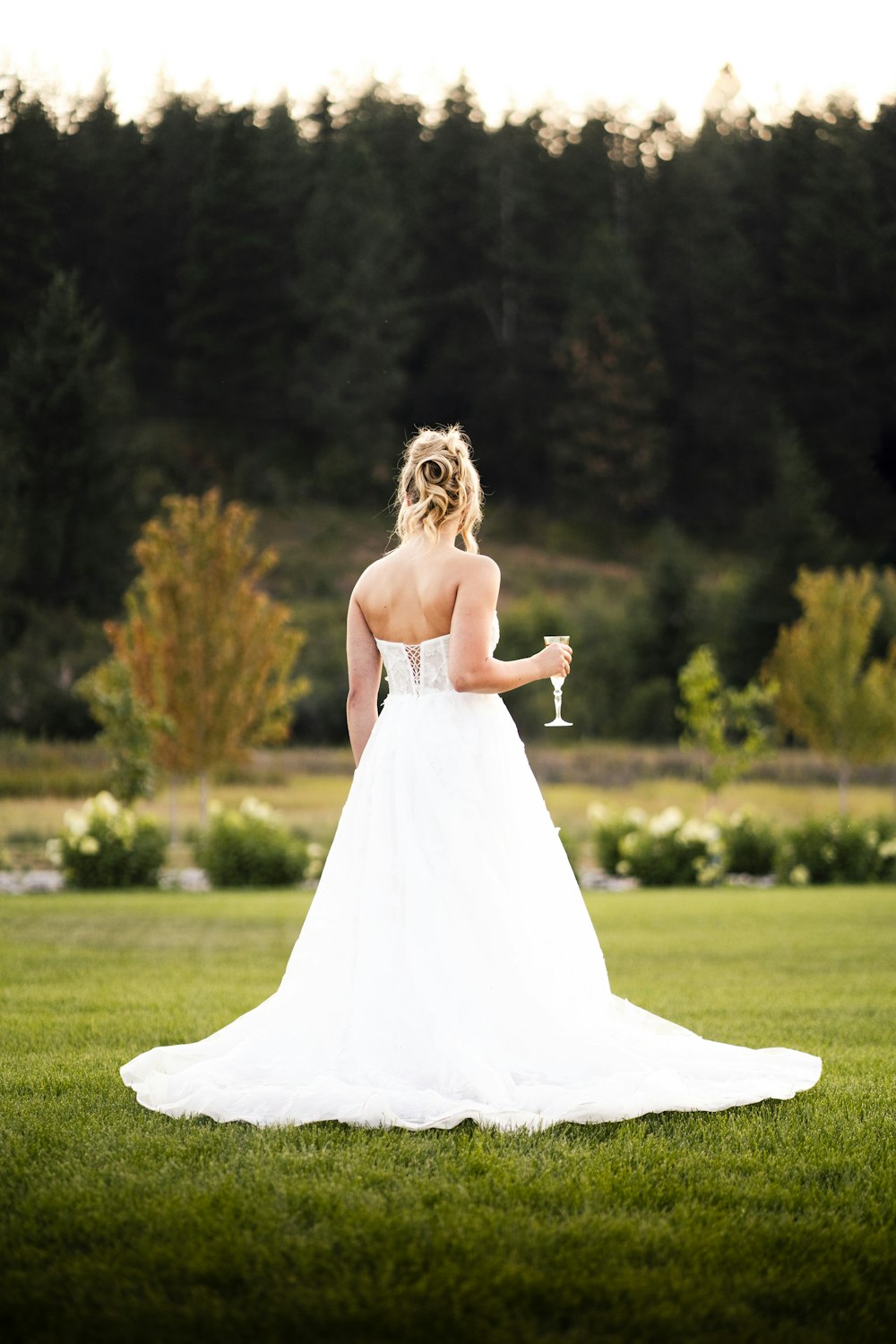 a woman in a wedding dress holding a wine glass