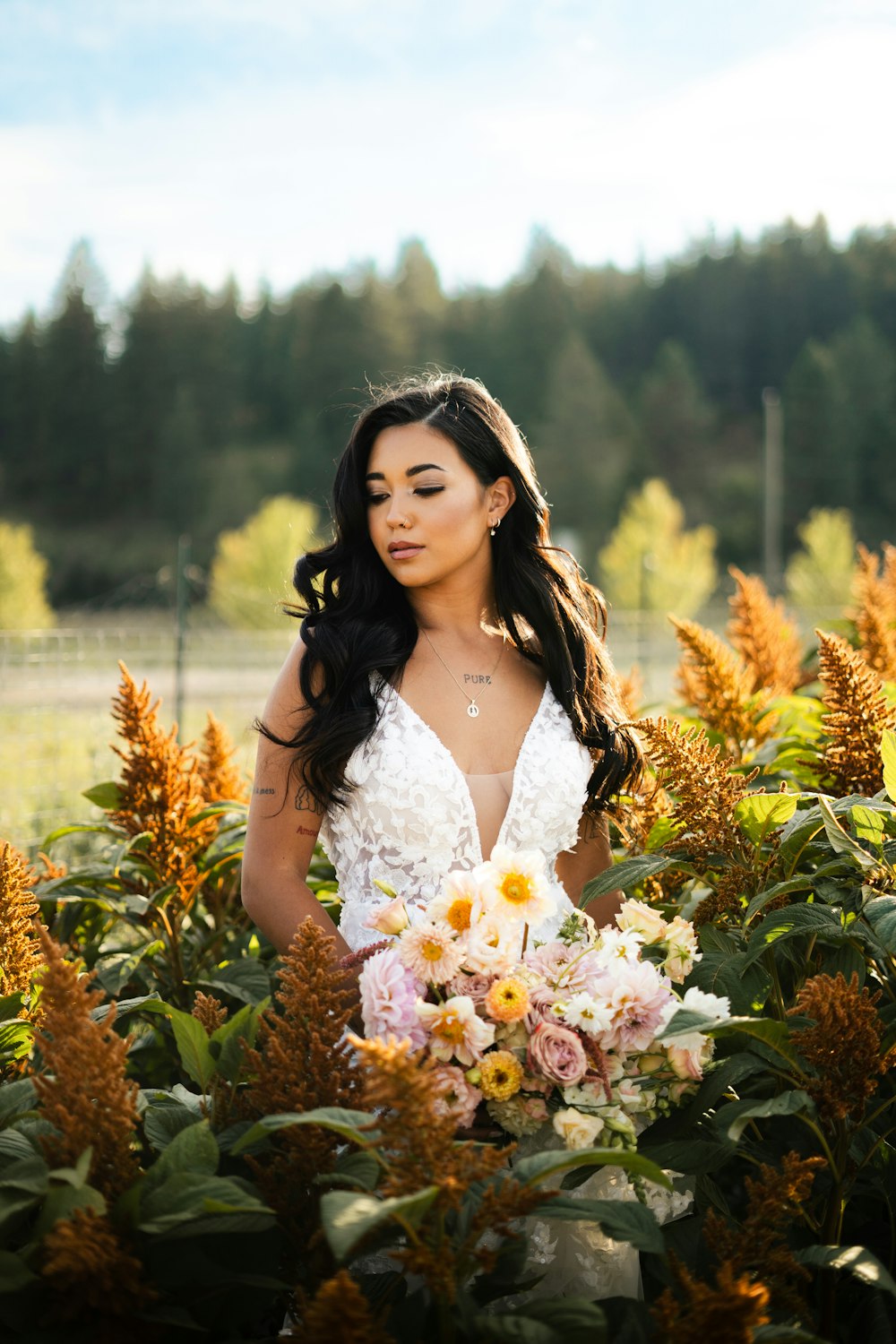 uma mulher em pé em um campo segurando um buquê de flores