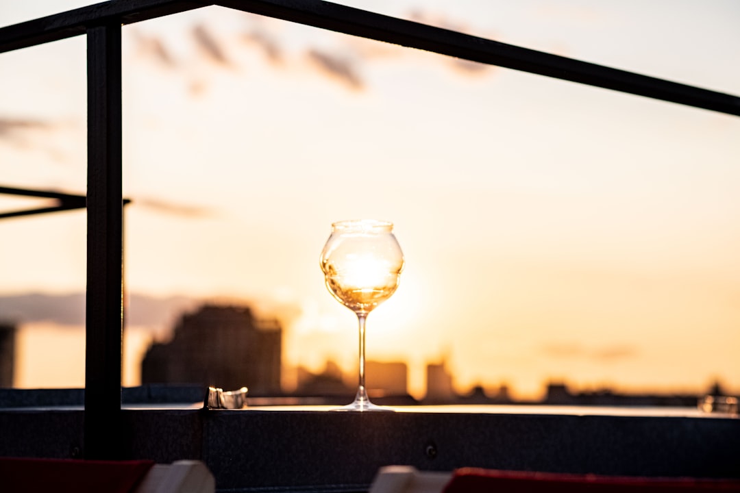 a glass of wine sitting on top of a table,