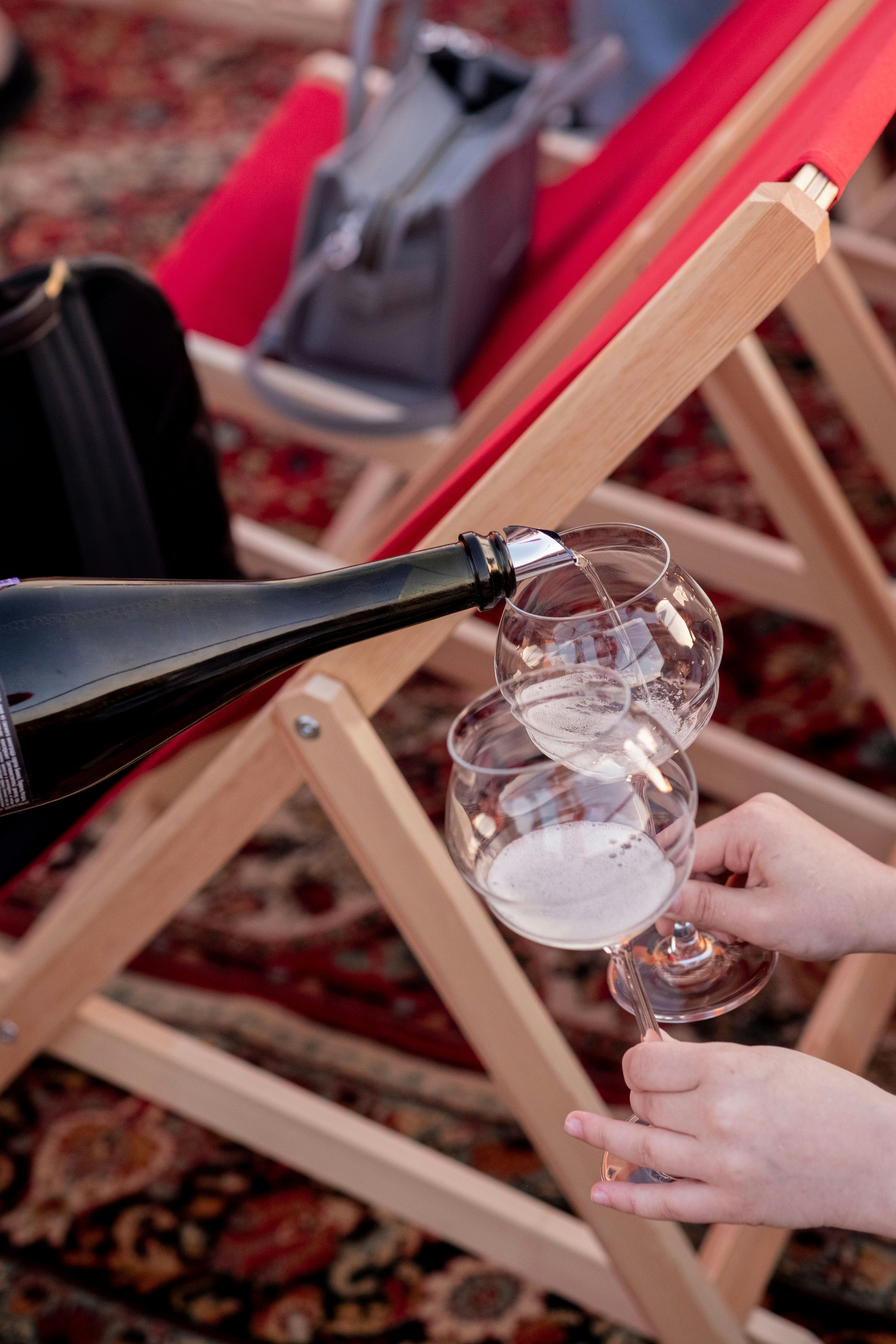 una persona che versa un bicchiere di vino in un bicchiere di vino