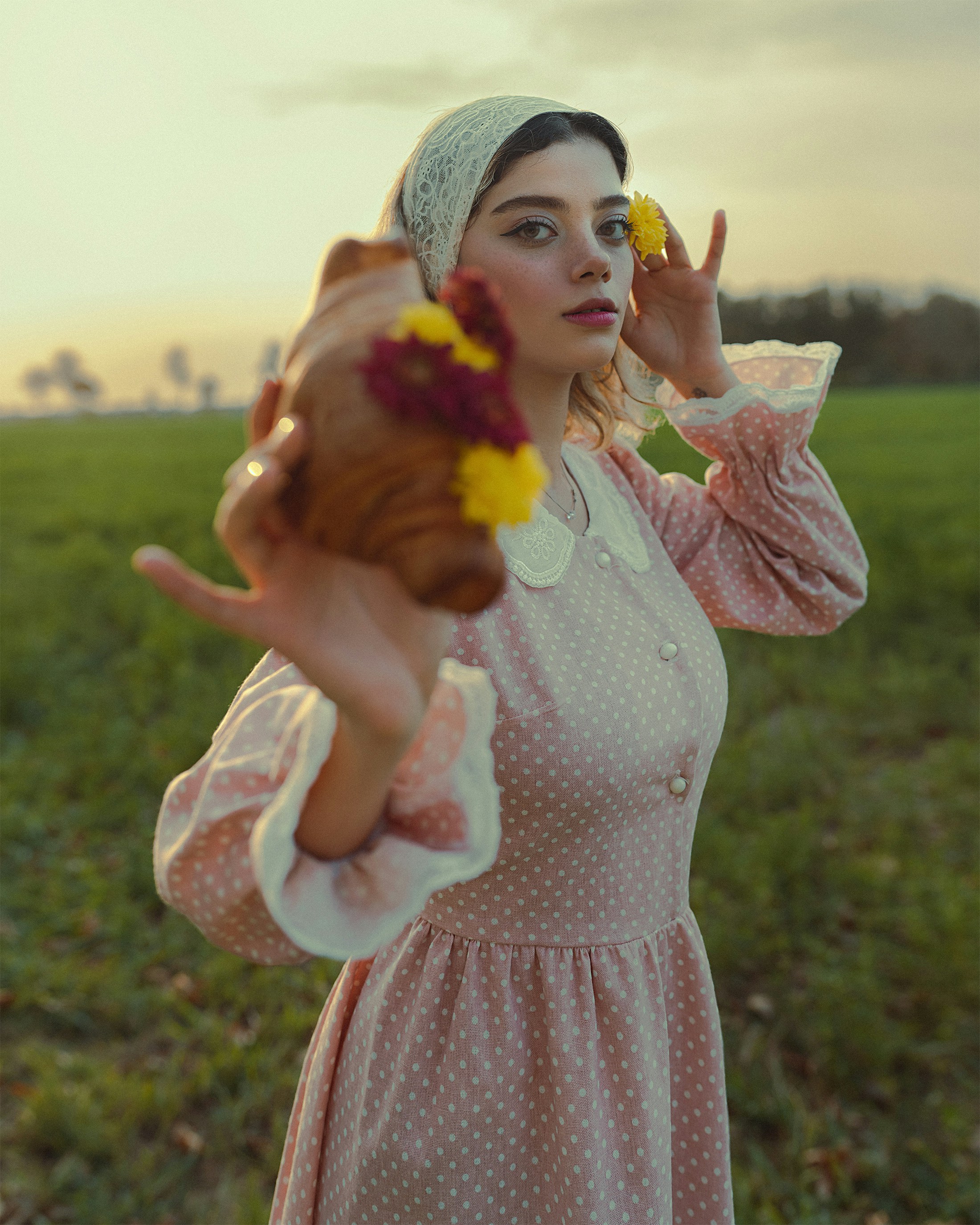 a woman in a pink dress holding a flower