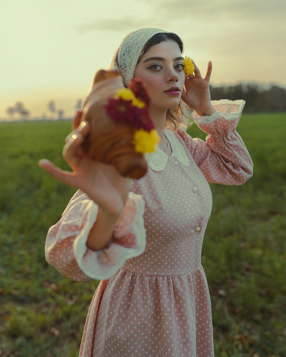 a woman in a pink dress holding a flower