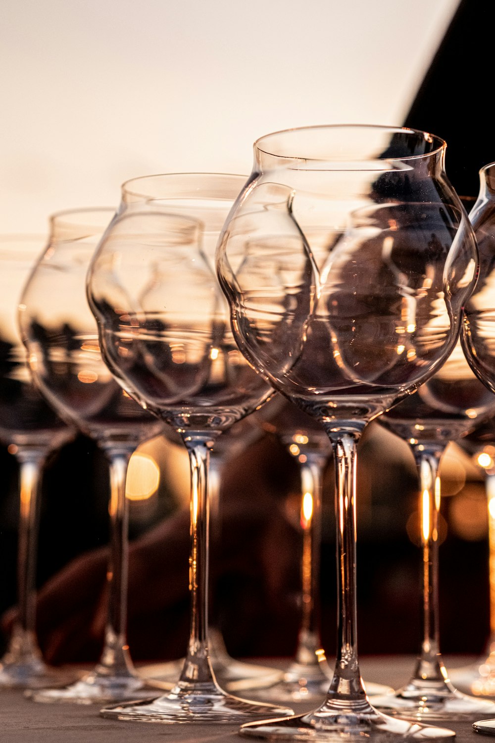 Una fila de copas de vino sentadas encima de una mesa