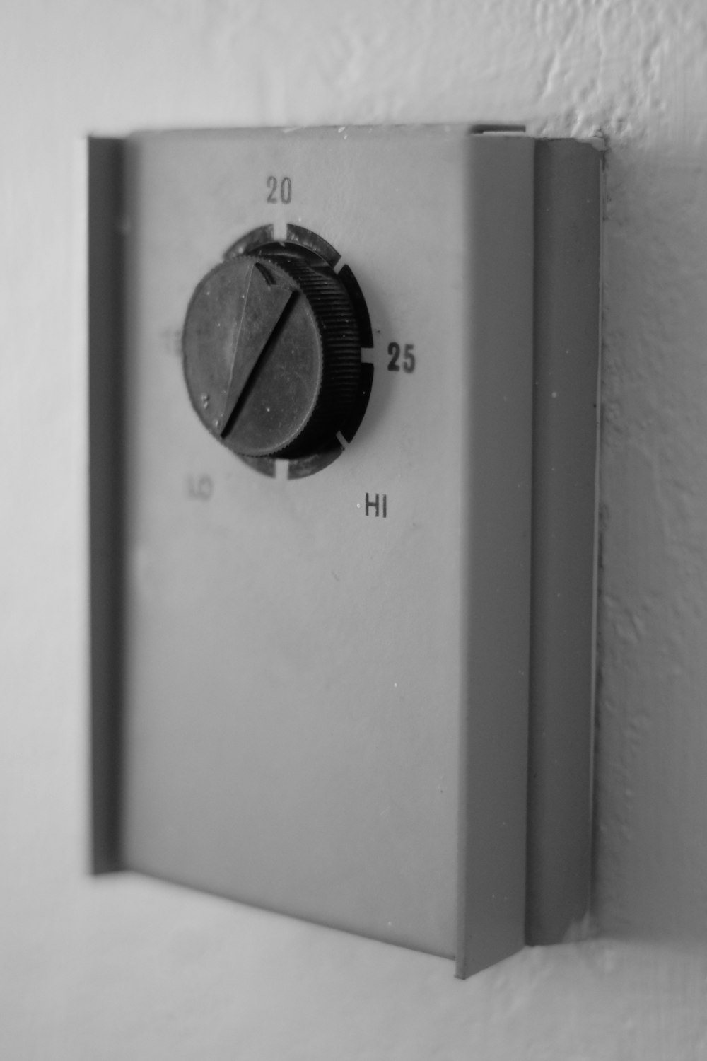 Una foto en blanco y negro de un botón en una pared