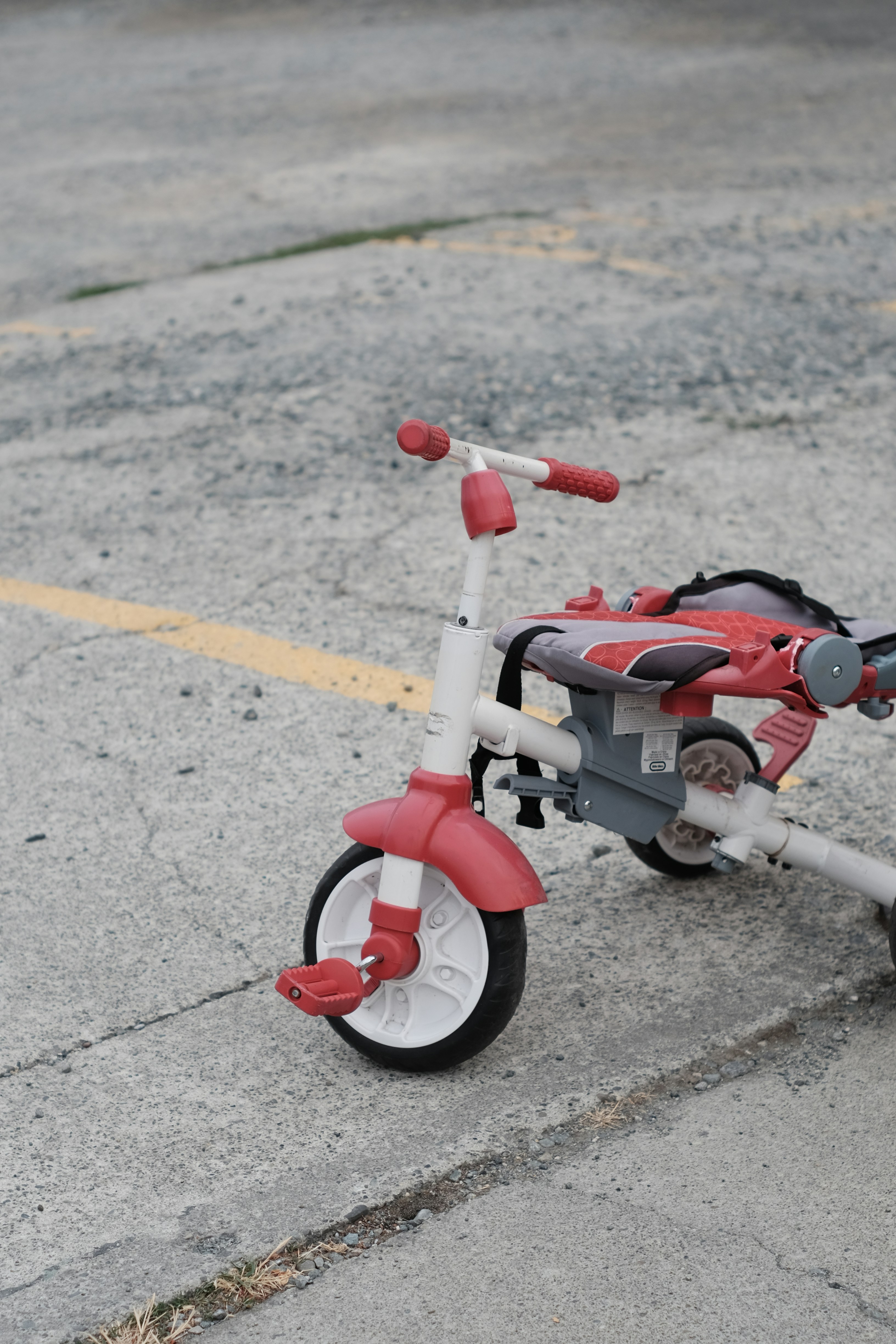 a red and white tricycle parked in a parking lot