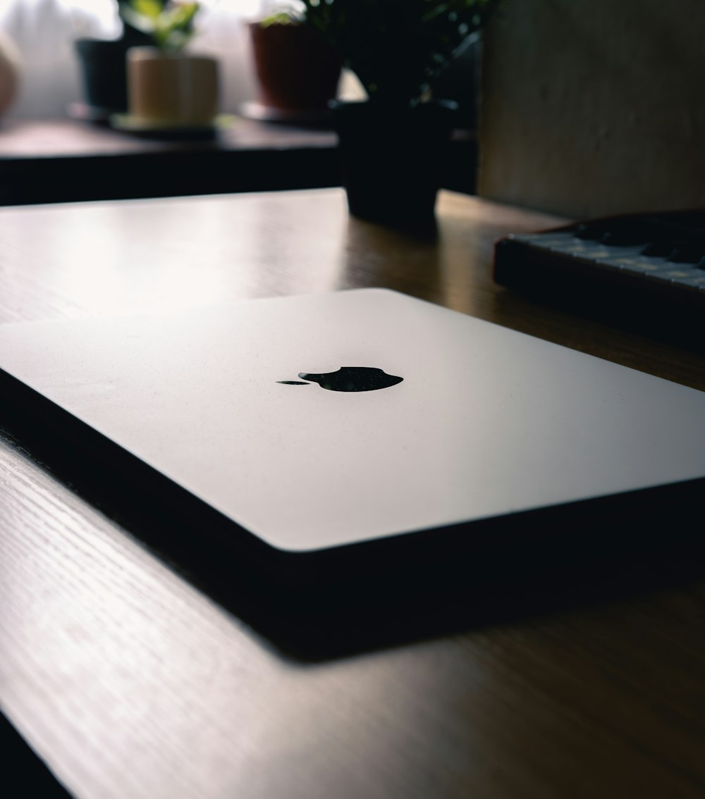an apple laptop sitting on top of a wooden table