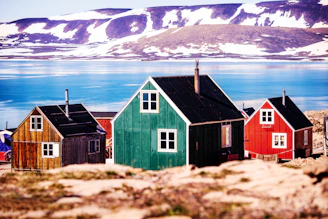 a group of small houses sitting on top of a rocky hillside Greenland