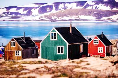 a group of small houses sitting on top of a rocky hillside Greenland
