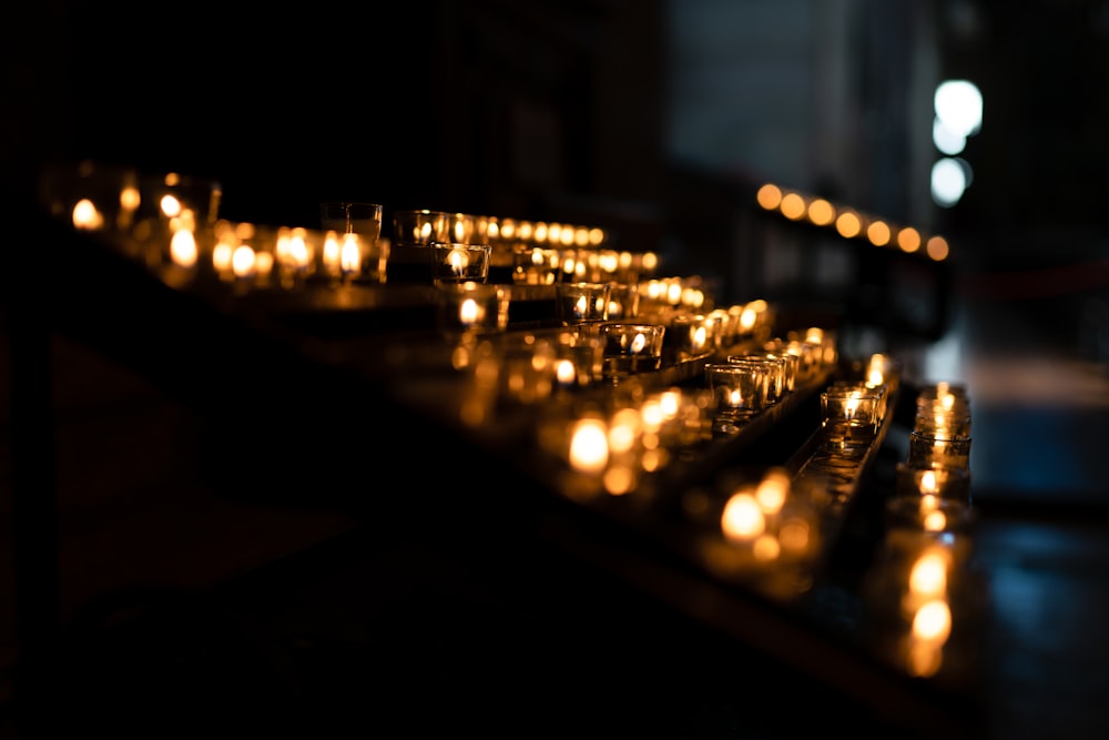 a row of lit candles sitting on top of a table