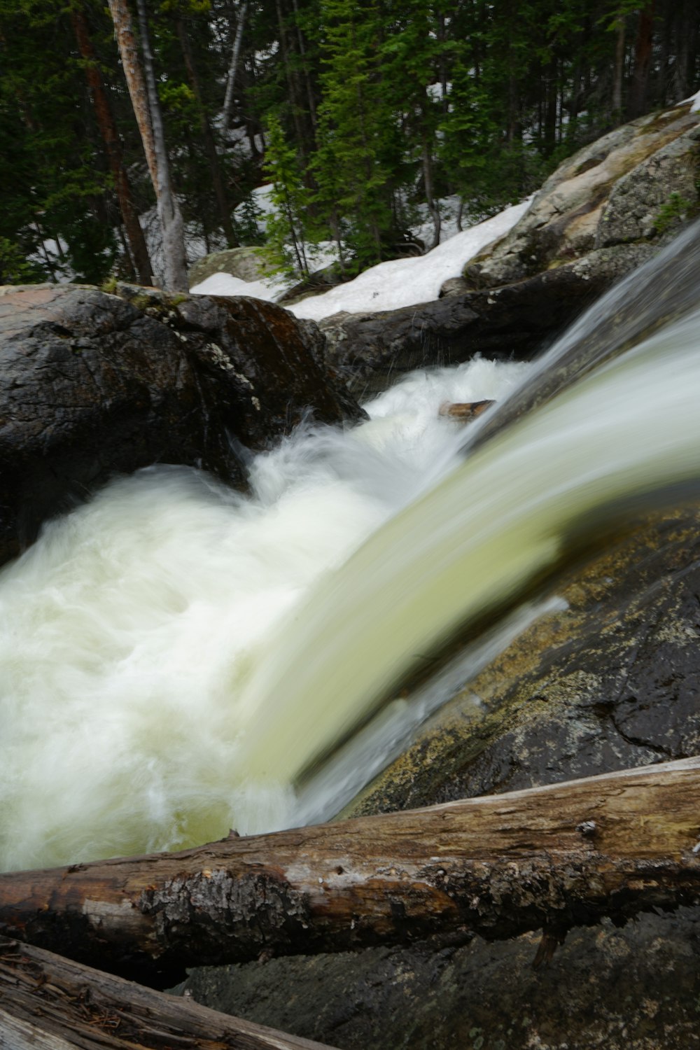 a stream of water running over rocks in a forest