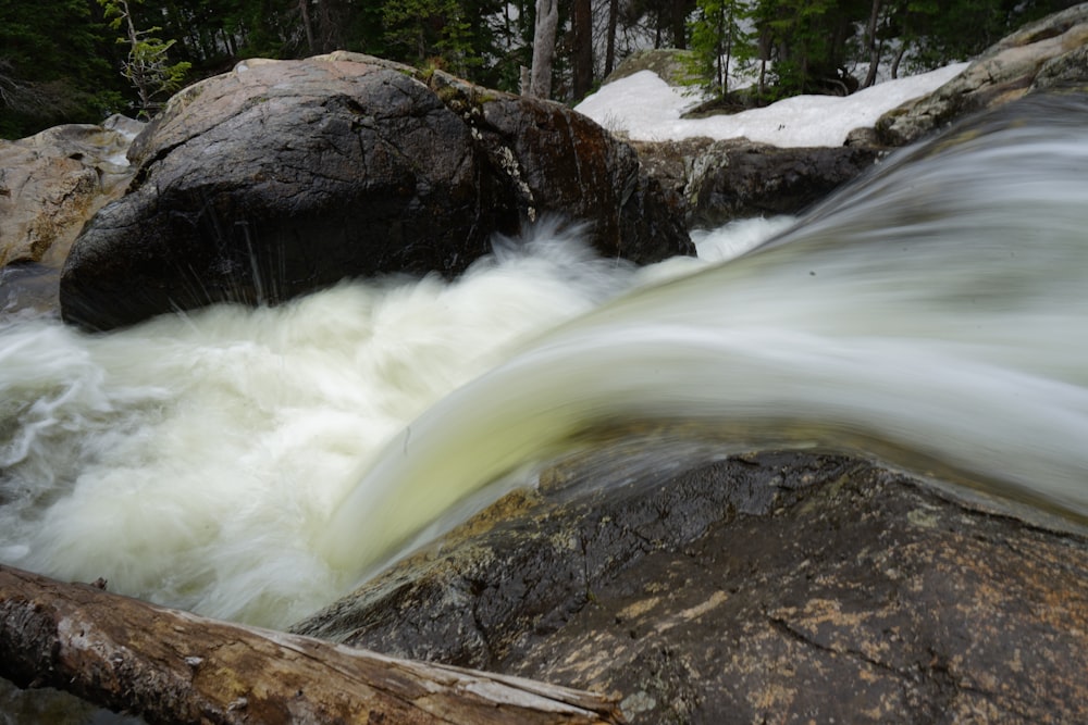 a stream of water running over rocks in a forest