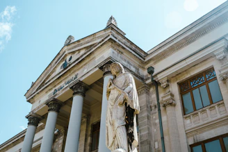 a statue stands in front of a building