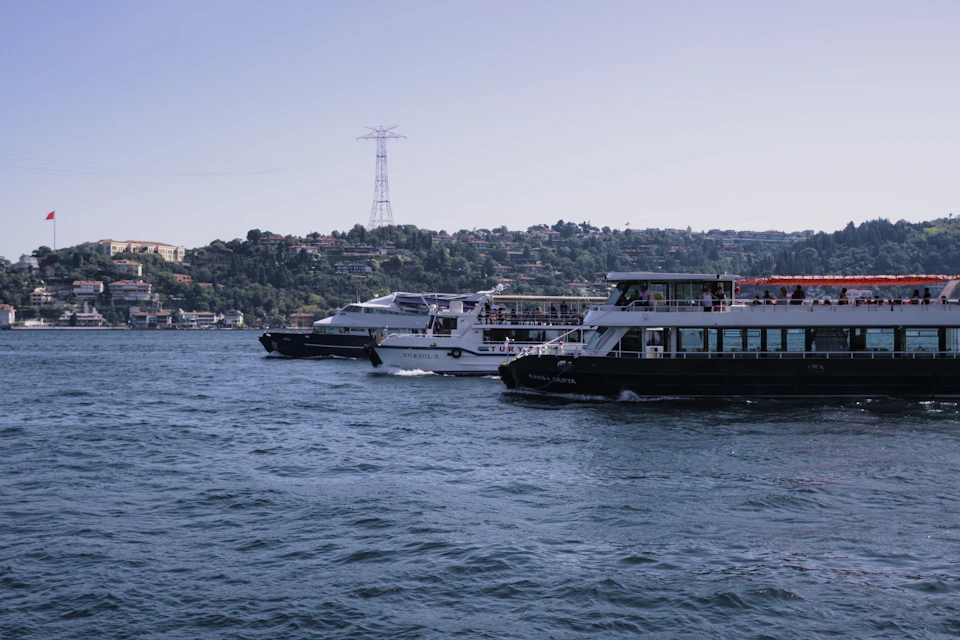 Three boats float on calm water, each with distinct design and vibrant colors displayed