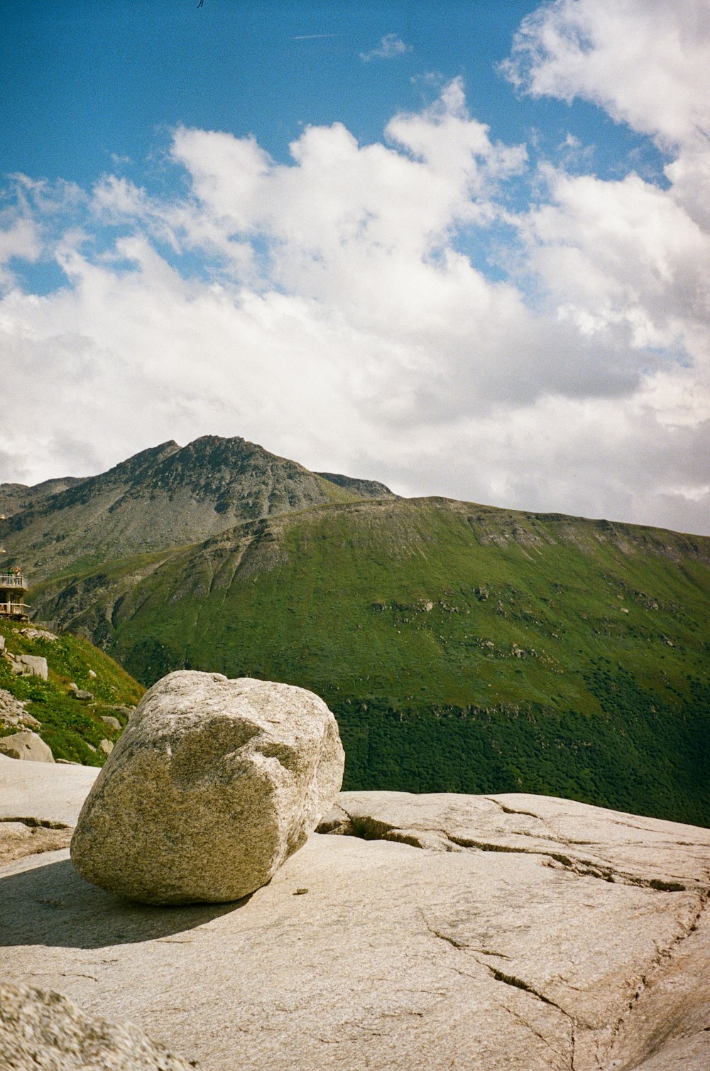 un gros rocher assis au sommet d’une montagne