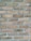 A close-up view of a brick wall composed of uniform rectangular bricks arranged in a horizontal pattern. The bricks are light brown and feature a rough texture, with grey mortar filling the gaps between them.
