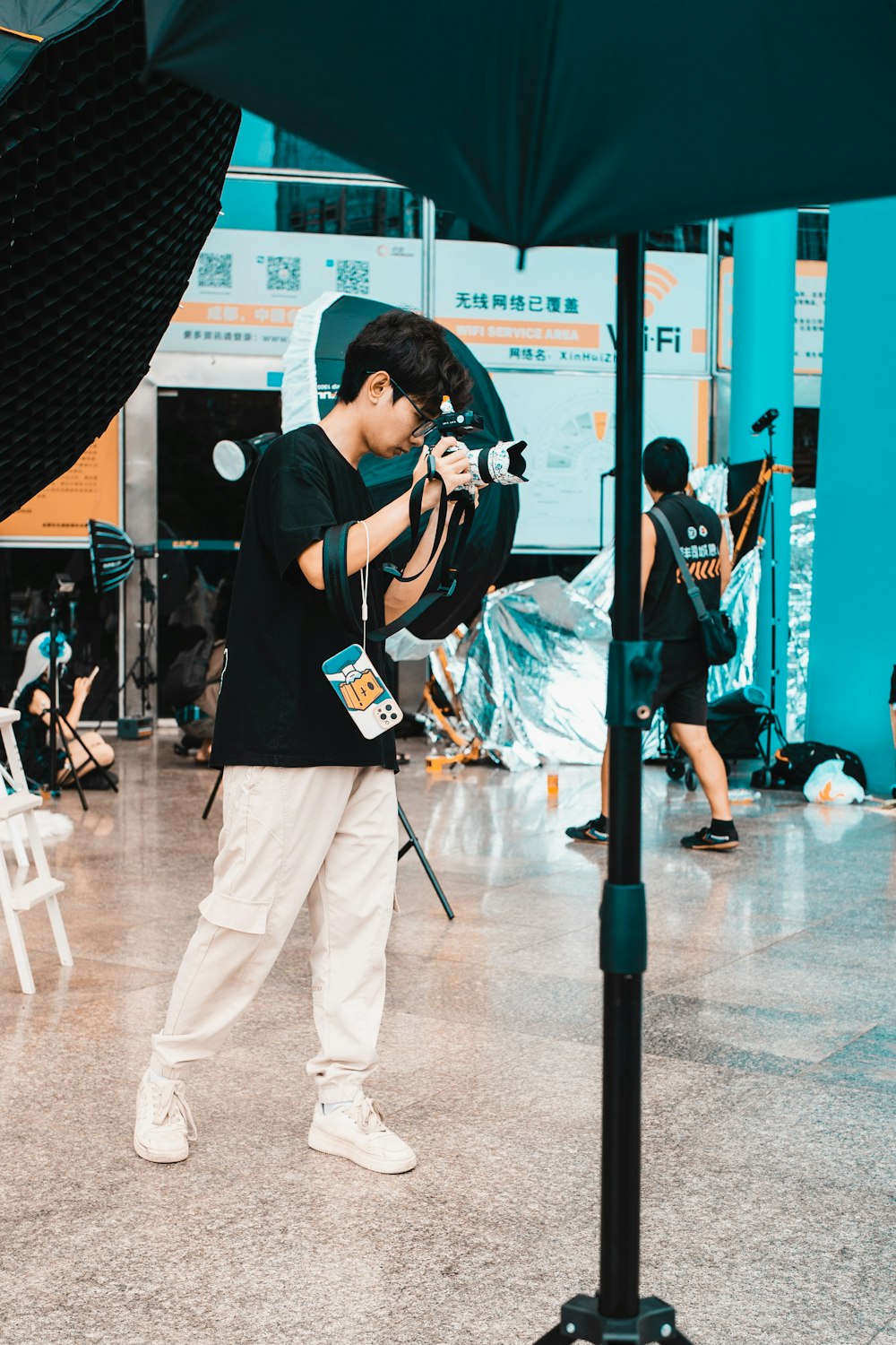 a man holding a camera in front of an umbrella