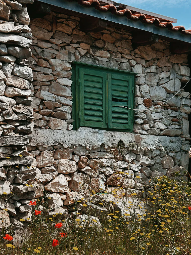 Stone cottage with green shutters