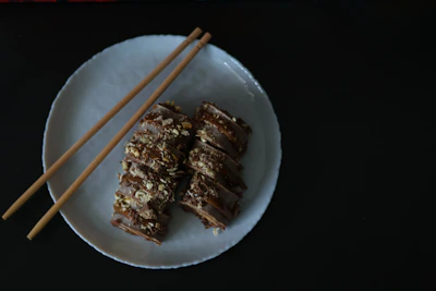 An elegant plate of sushi and premium dishes artfully arranged on a dark wooden table with subtle glow accents.