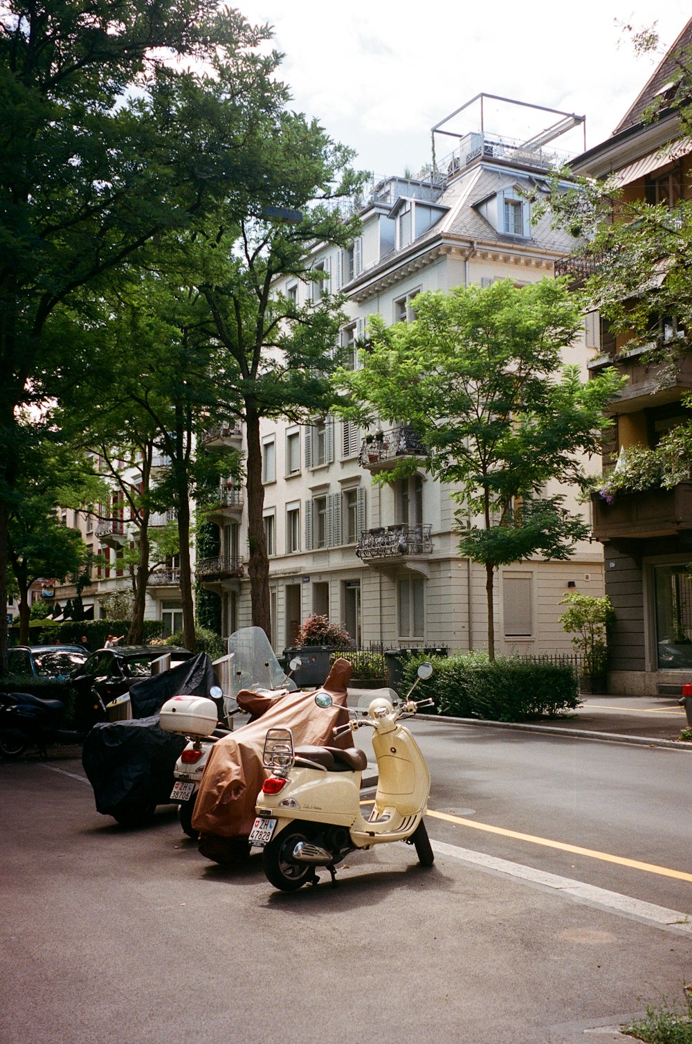 a row of scooters parked on the side of a street