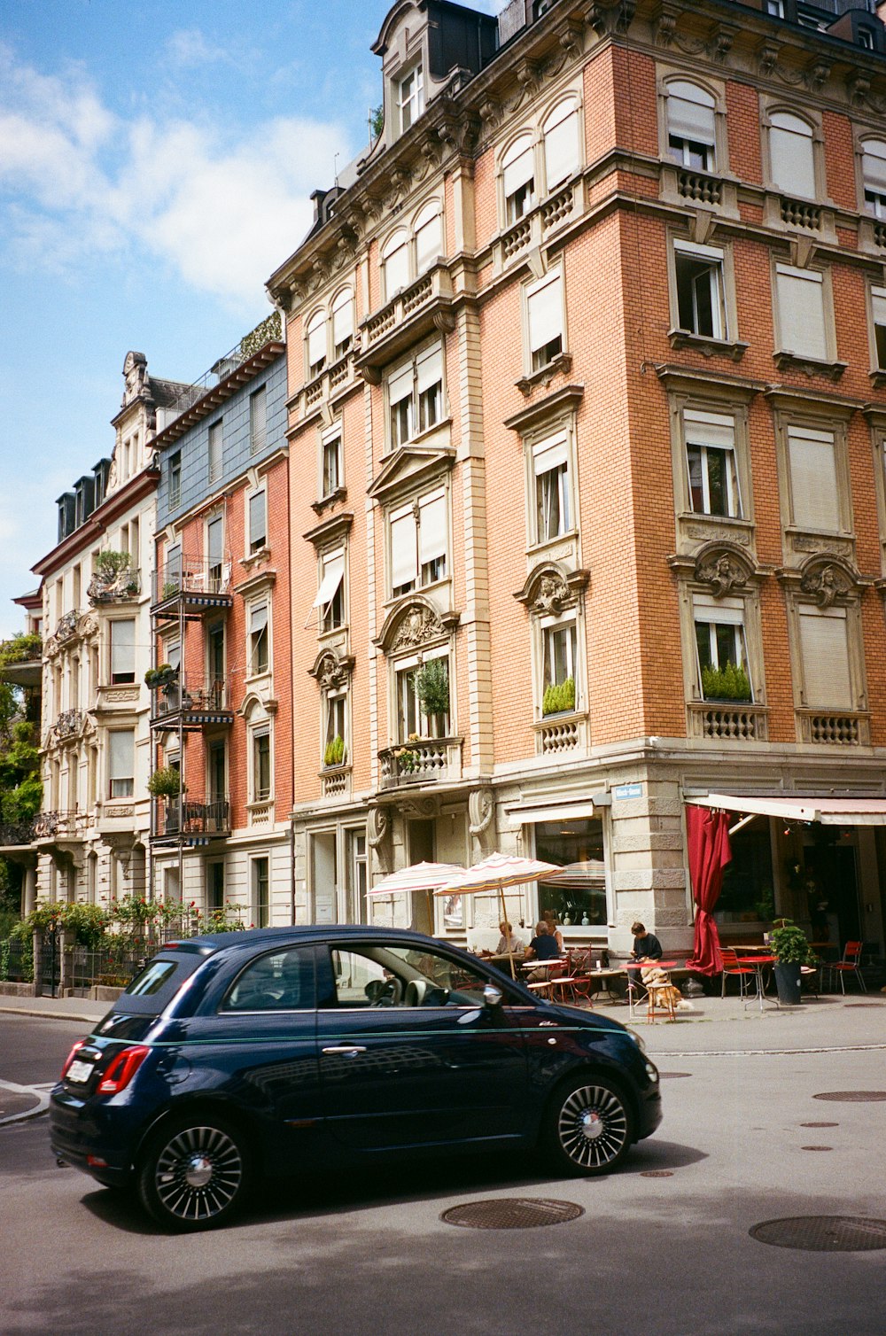 a car parked in front of a tall building