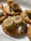 Golden crackers topped with a creamy white spread and garnished with sliced green olives, each featuring a pimento stuffing in the center.