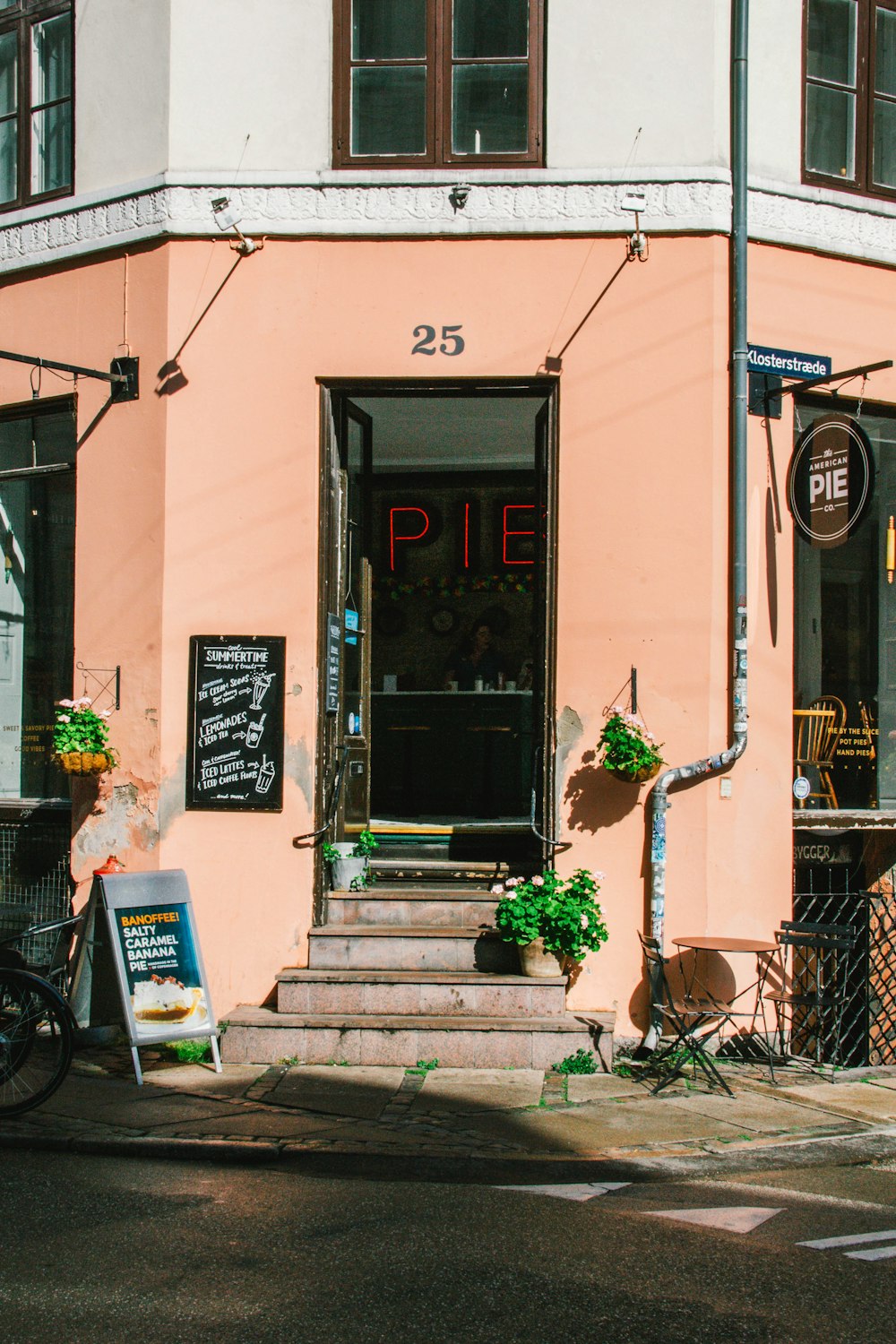 un bâtiment rose avec un vélo garé devant lui