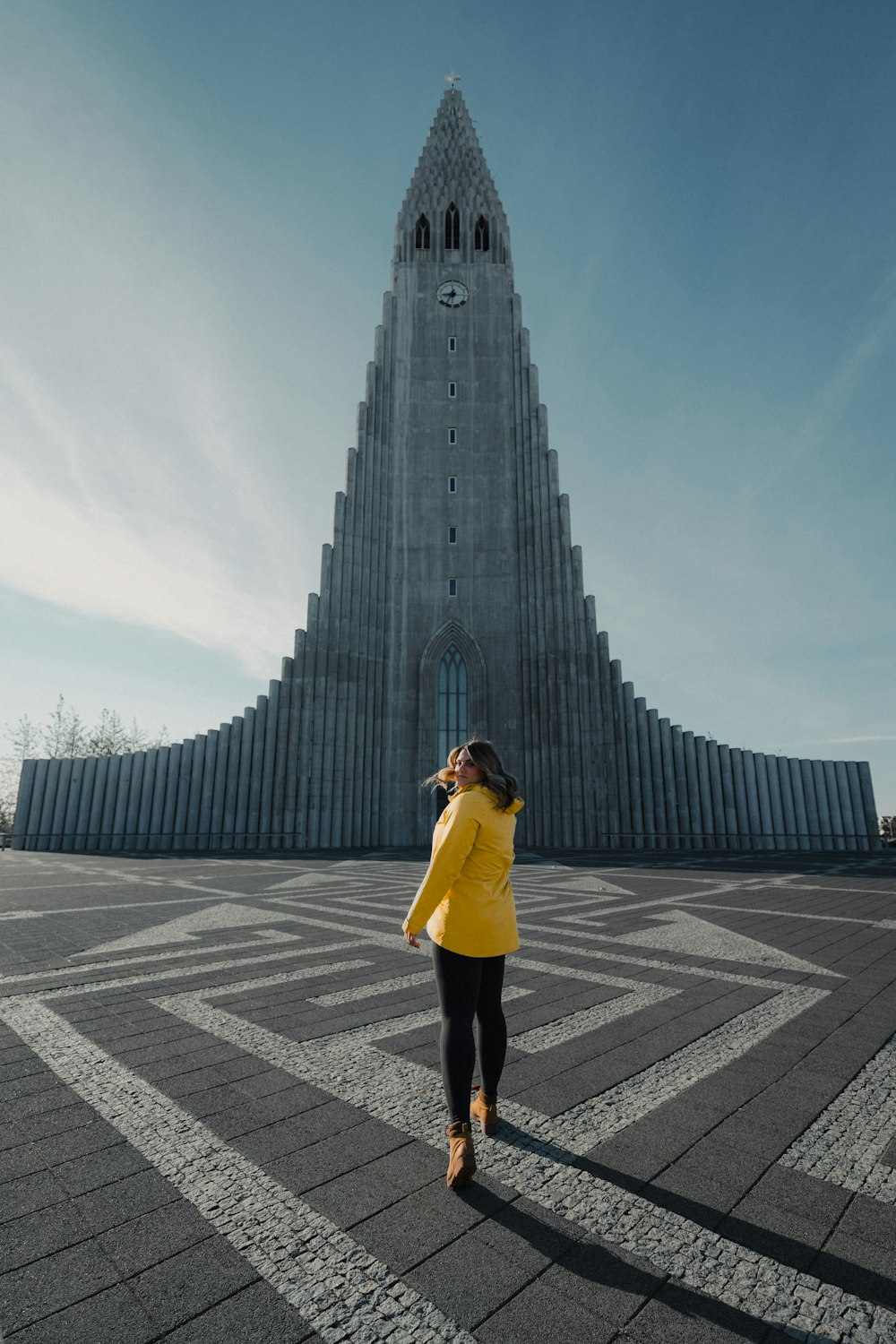a woman standing in front of a very tall building