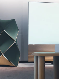 A sleek modern architectural office interior with dark green, black, and gold matte accents.