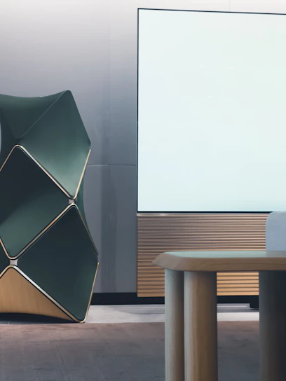 A sleek modern architectural office interior with dark green, black, and gold matte accents.
