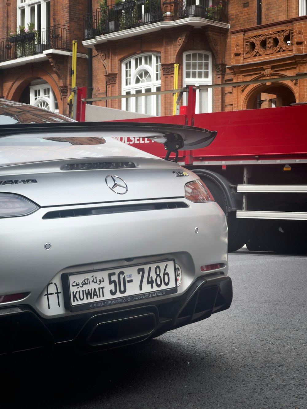 a silver sports car parked in front of a building