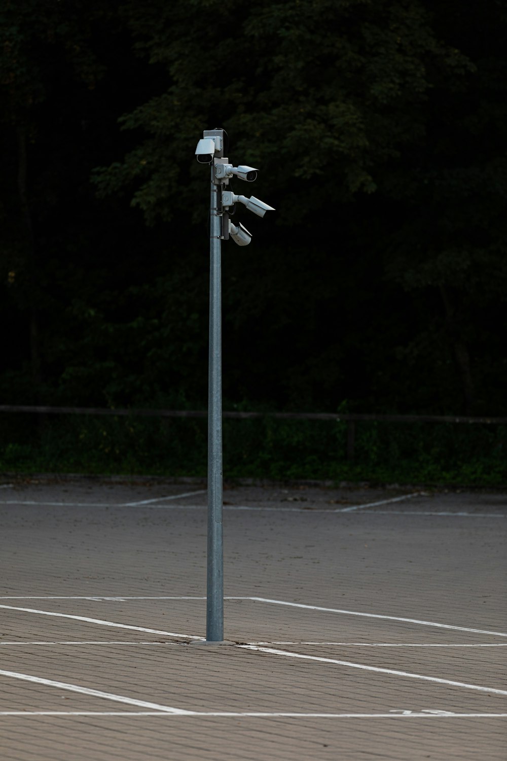 a parking lot with a street light and trees in the background