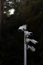 a group of security cameras on a metal pole