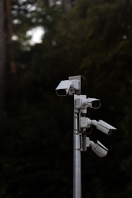 a group of security cameras on a metal pole