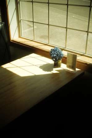 Sunlight streaming through a window onto a rustic table with a latte and a fresh pastry.
