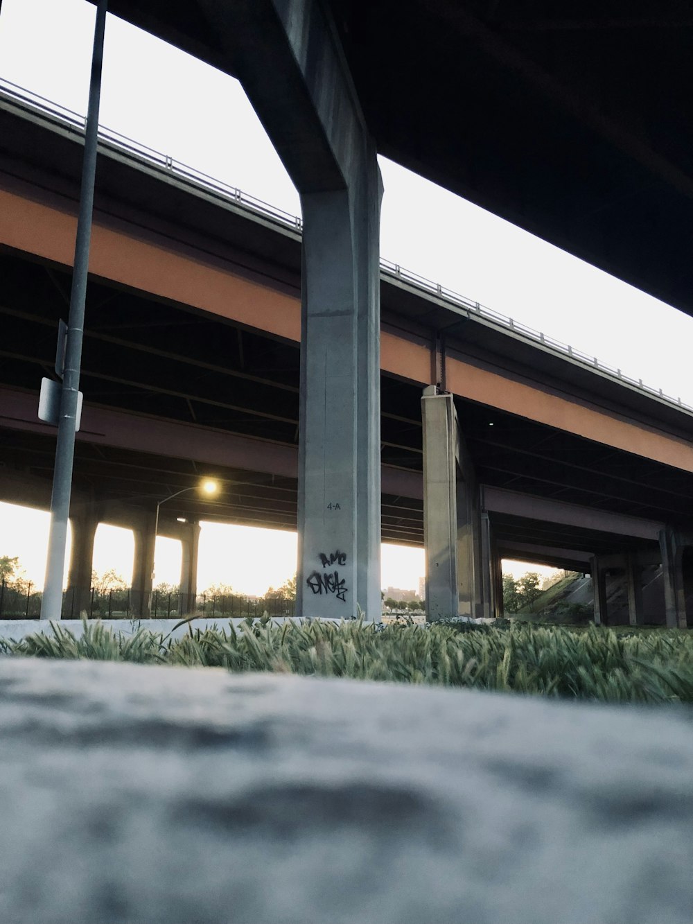 a skateboarder is doing a trick under a bridge
