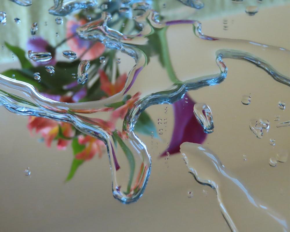 a vase filled with water and flowers on top of a table