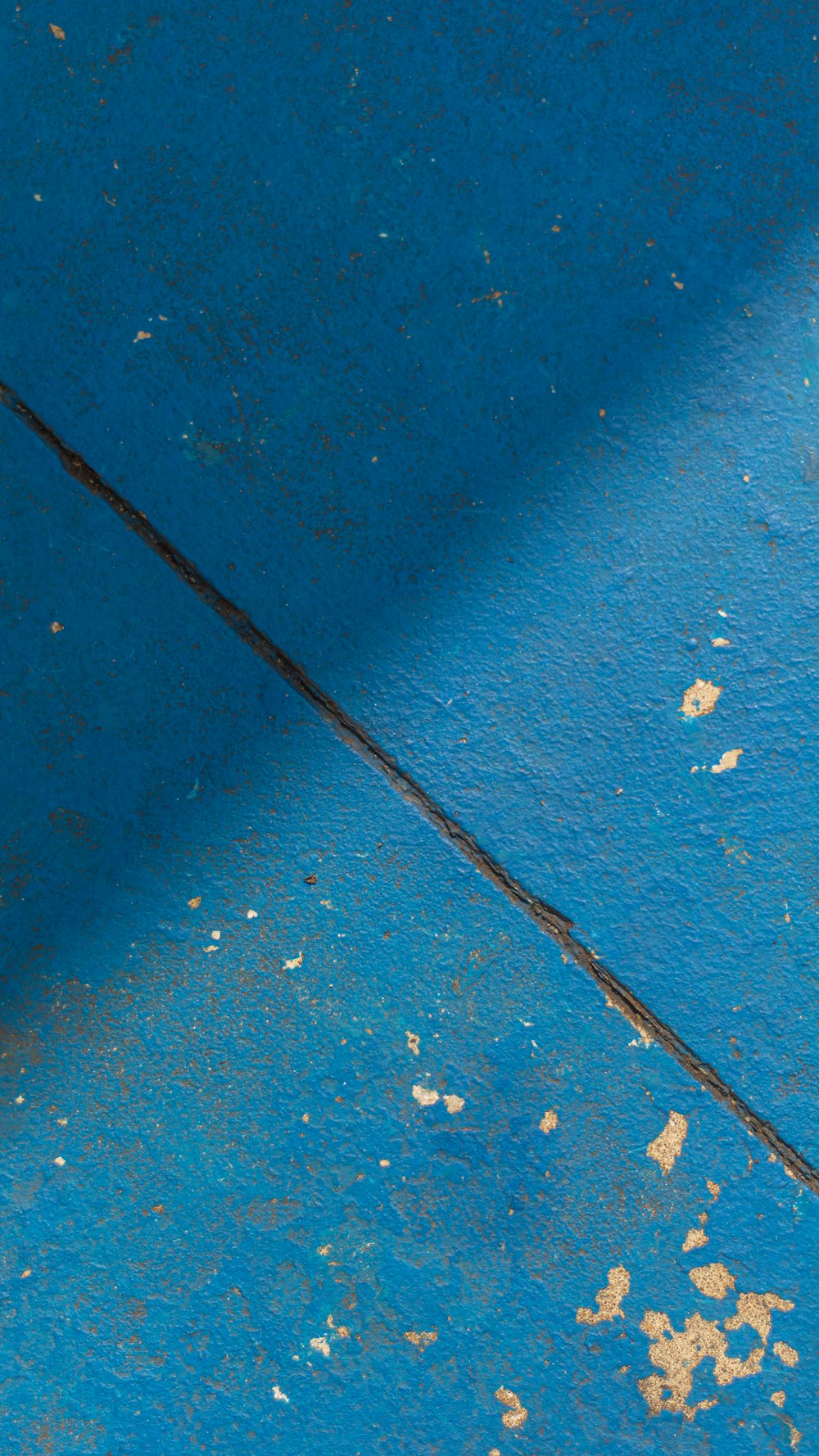 a red and white fire hydrant sitting next to a blue wall