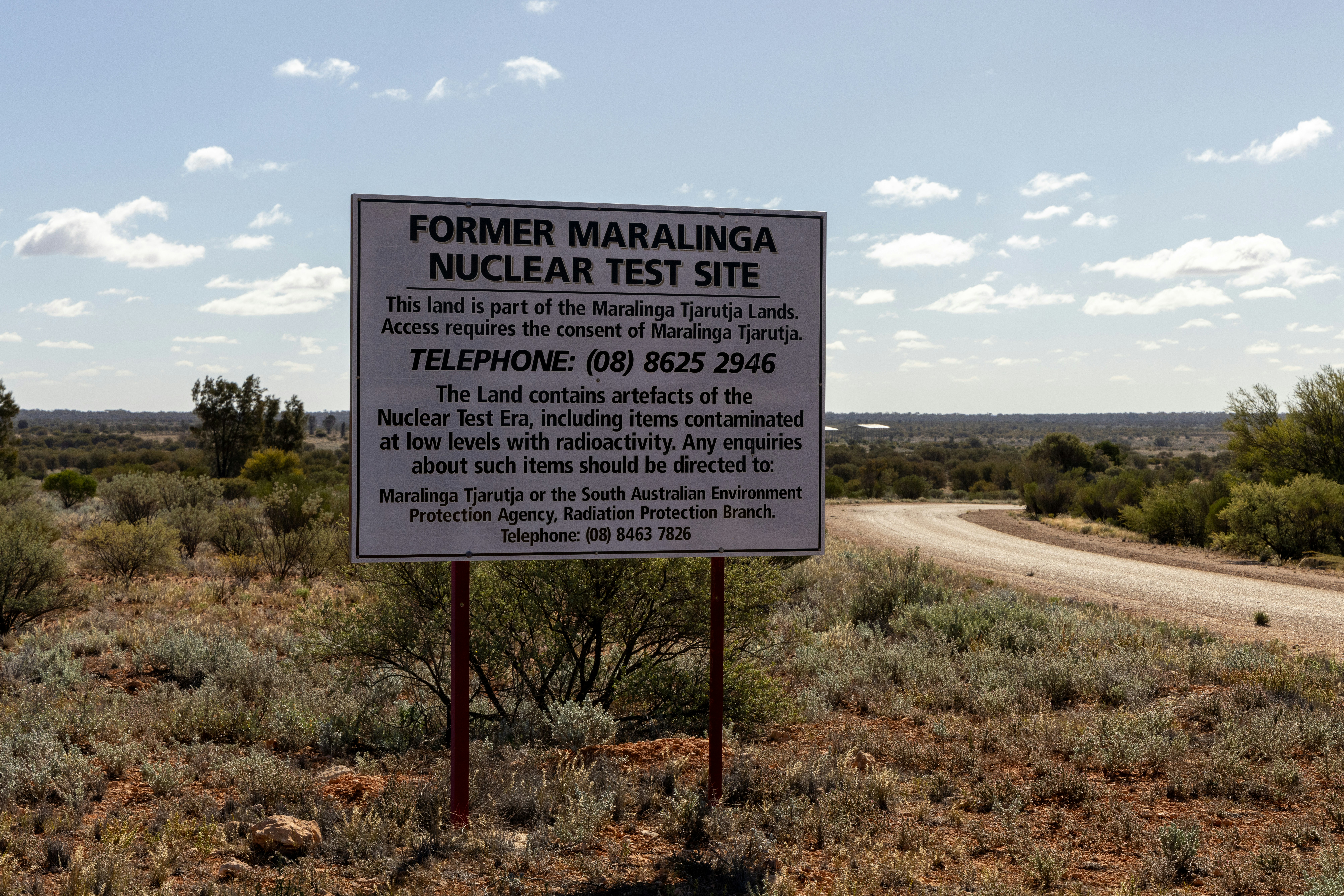 a sign on the side of a dirt road