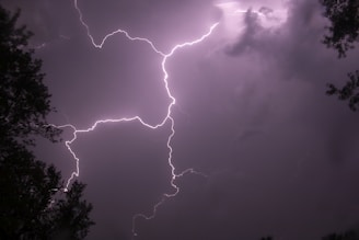 a lightning bolt hitting through a cloudy sky