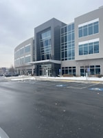 3D model of an office complex showcasing the external facade and parking area.