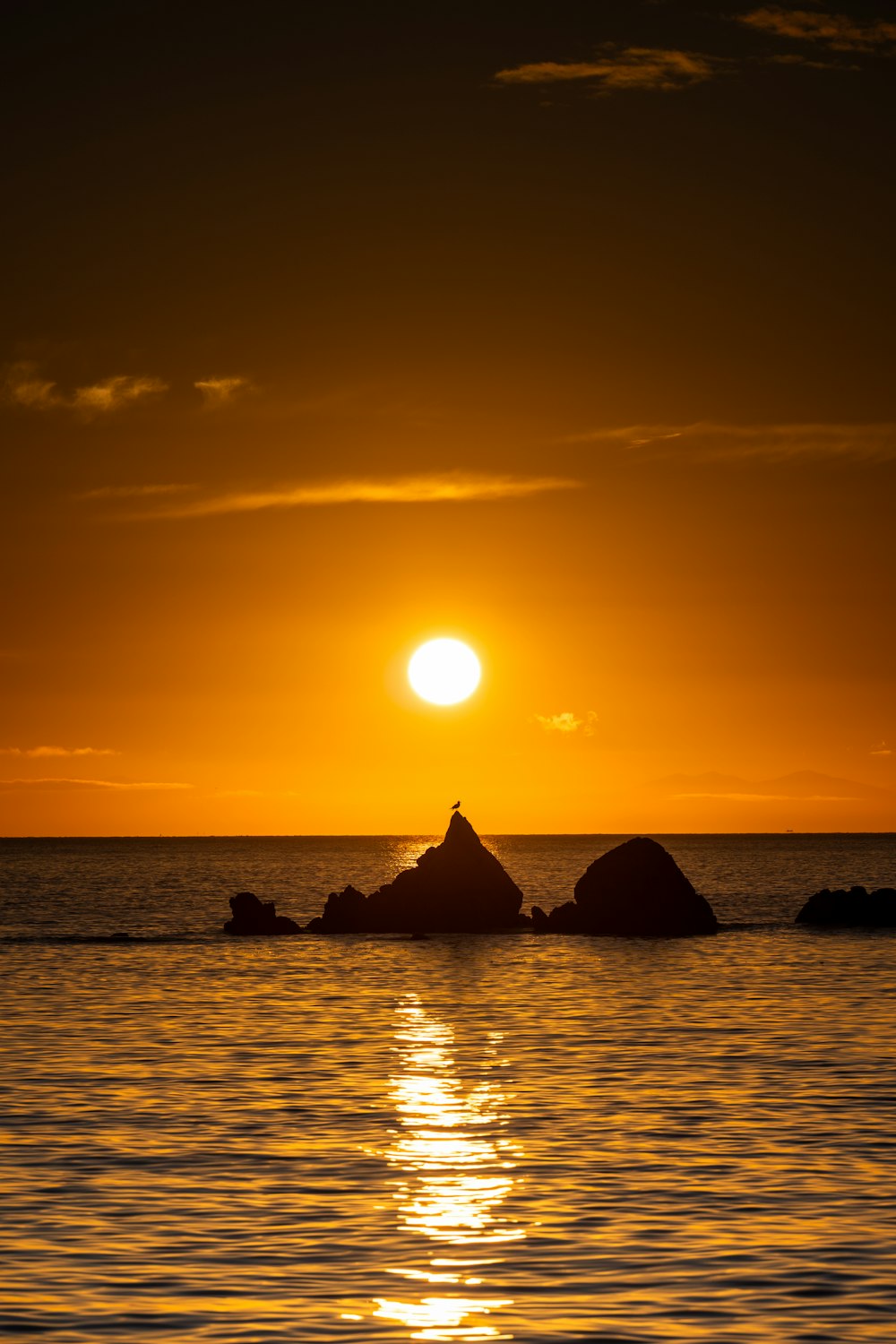 a large body of water with a sunset in the background