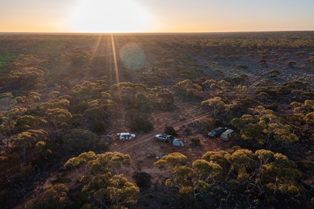 an aerial view of a dirt field with trees