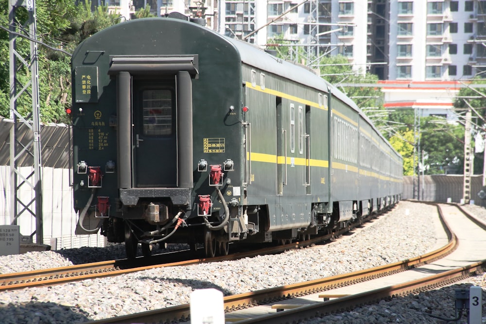 a train on a train track with buildings in the background