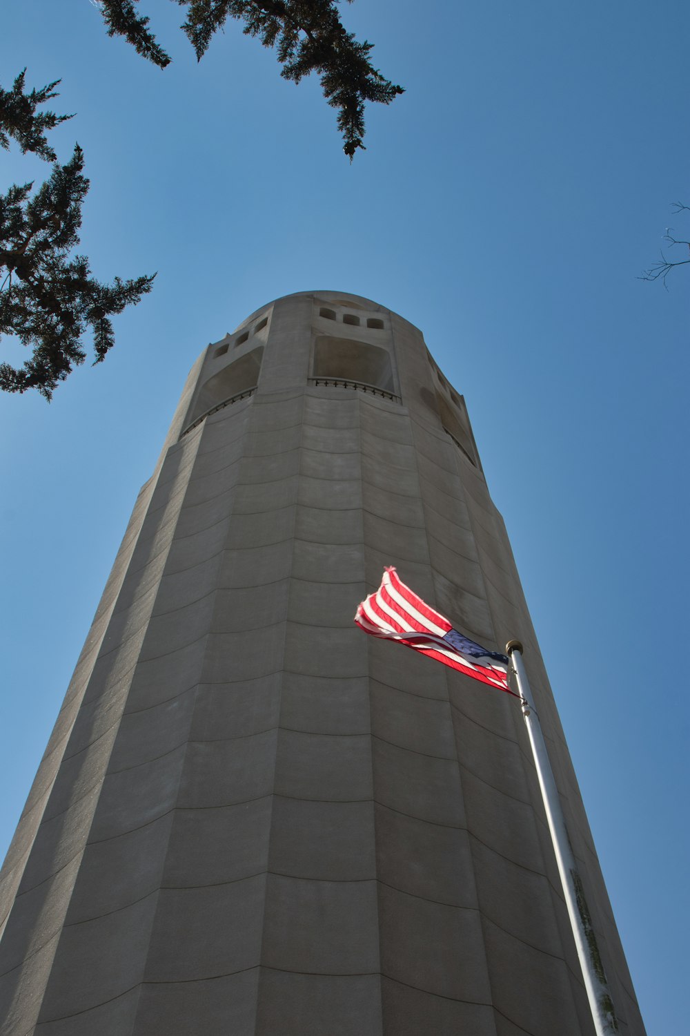 an american flag flying in front of a tall building