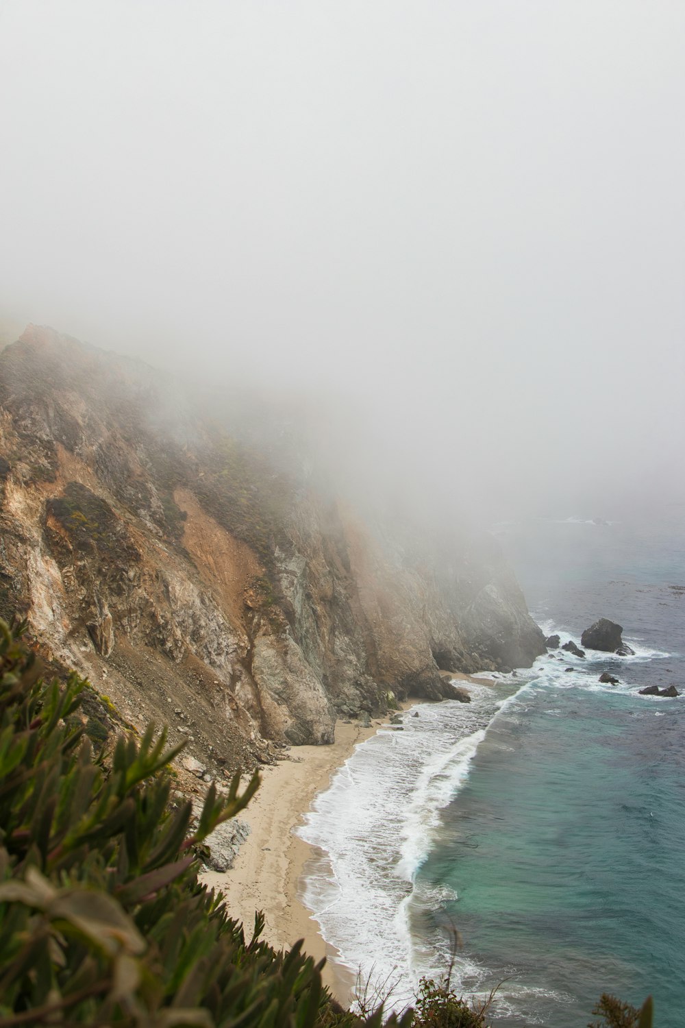 a foggy day at the beach with a view of the ocean